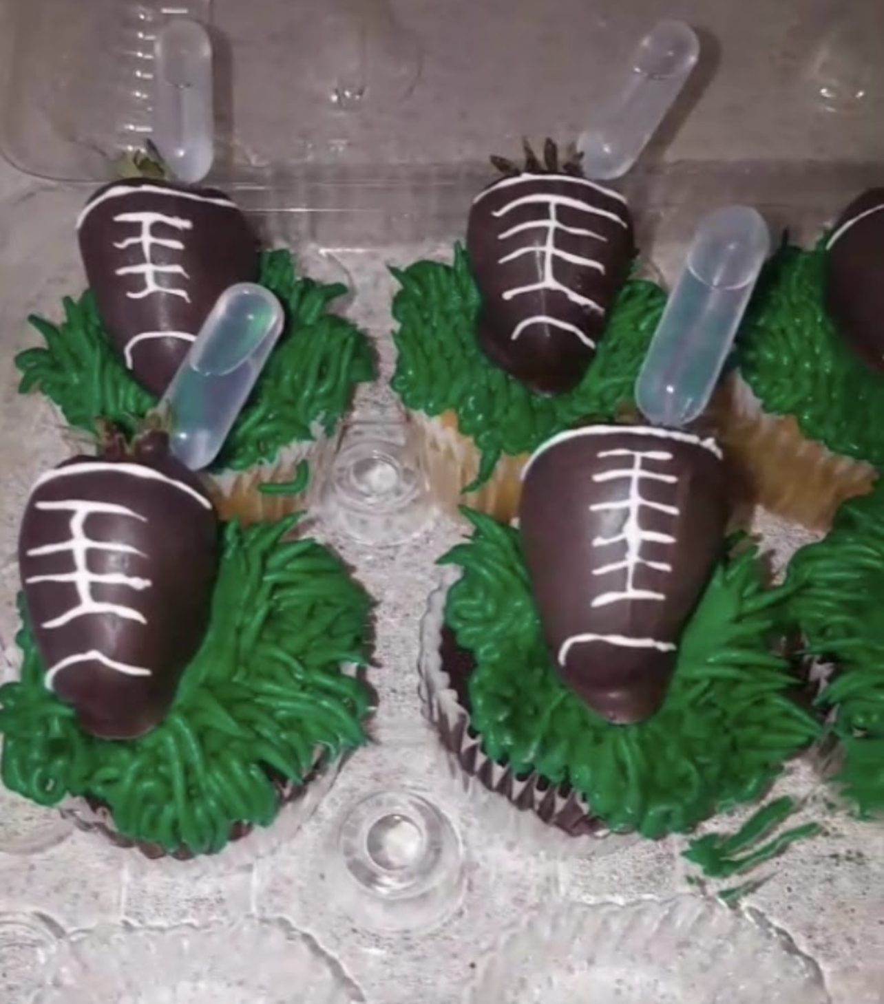 Football themed cupcakes with chocolate dipped strawberry toppers