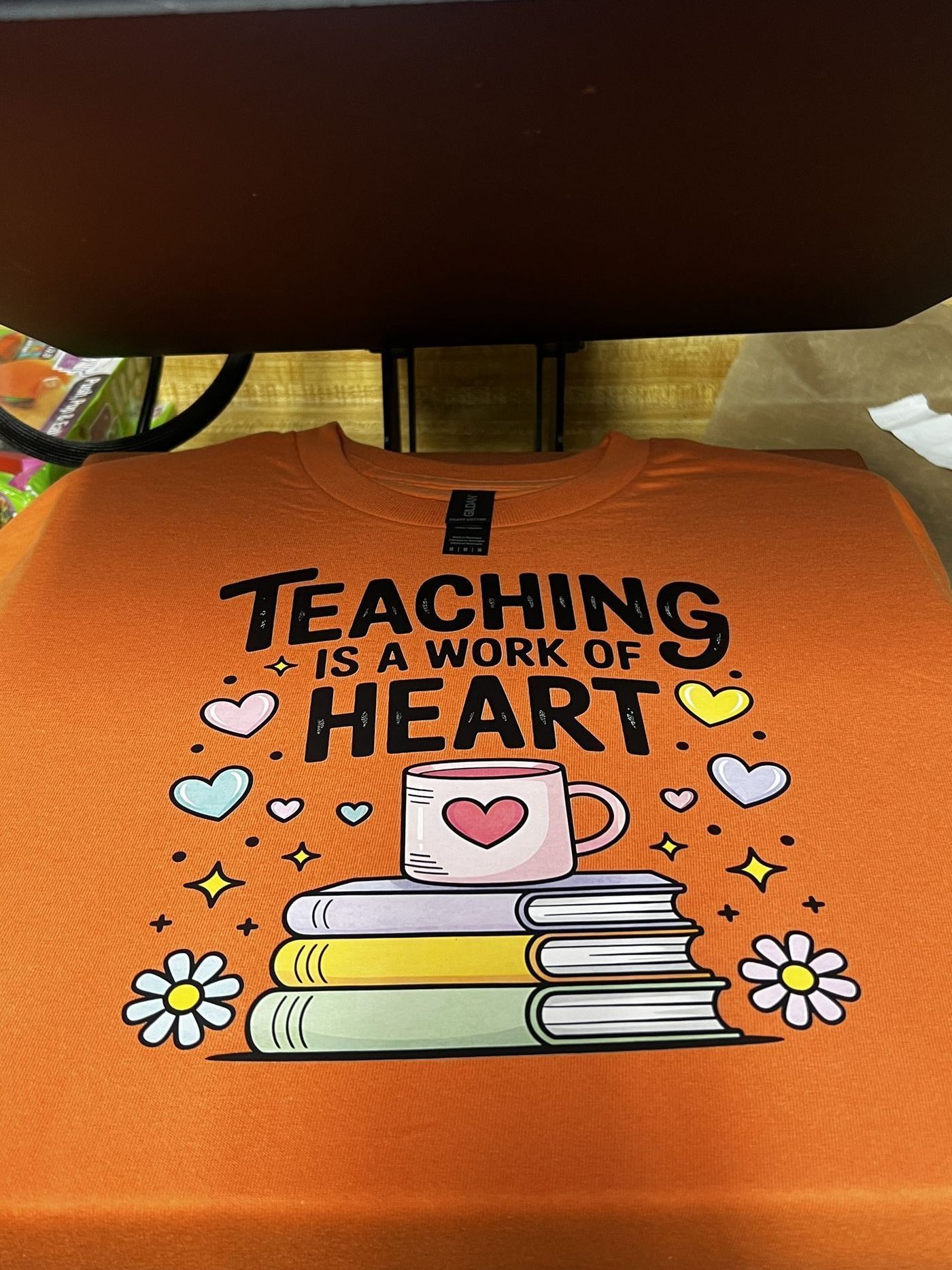 Custom orange tumbler with Teaching is a Work of Heart design and daisy details