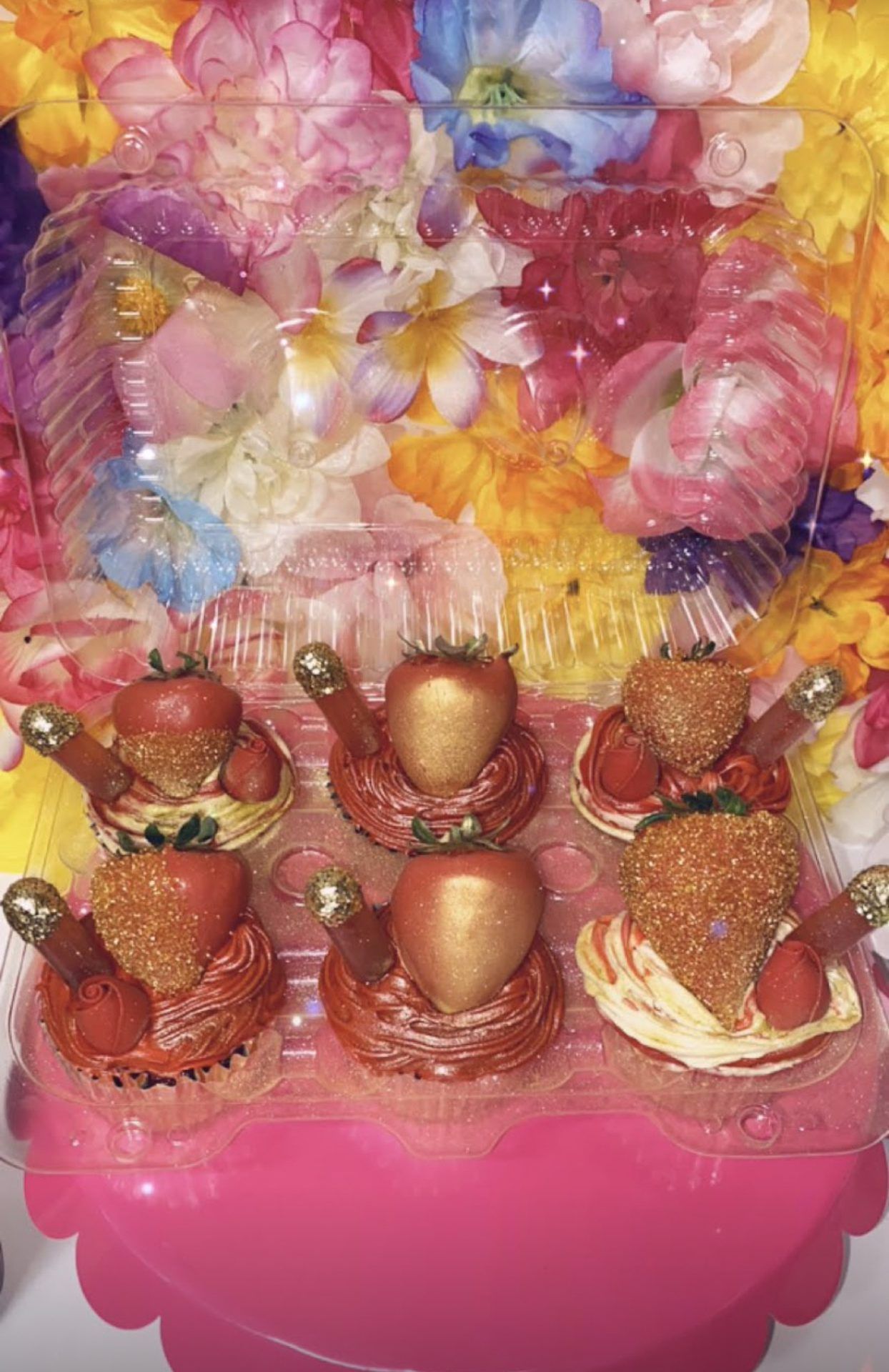 Gold dipped strawberries with decorated cupcakes on floral display